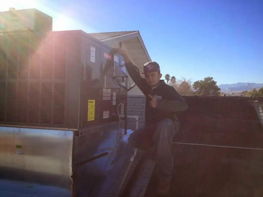 HVAC technician performing Air Duct Repair on a rooftop unit in Wichita